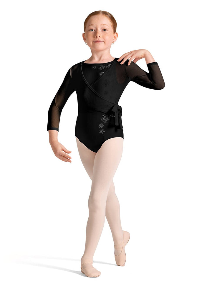 Young dancer in a black leotard with floral details on a white background
