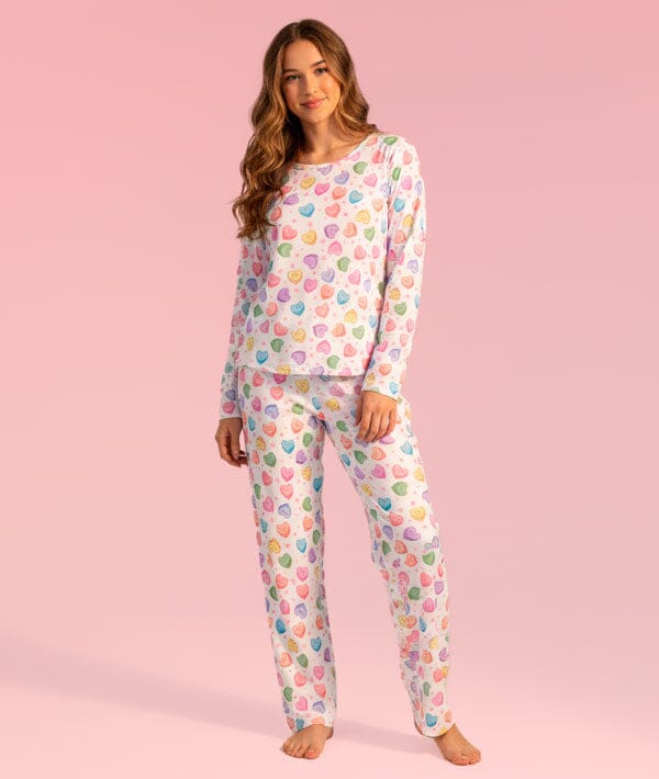 Woman wearing a colorful pajama set on a pink background