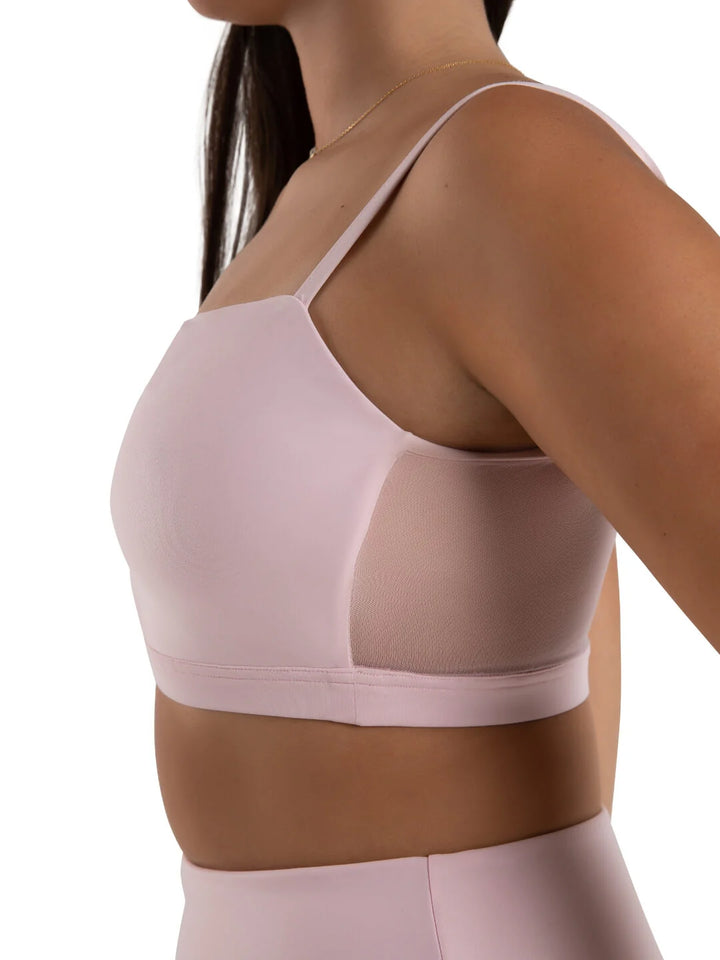 Light pink sports bra worn by a person on a white background