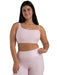 Woman wearing a pink sports bra and leggings set on a white background