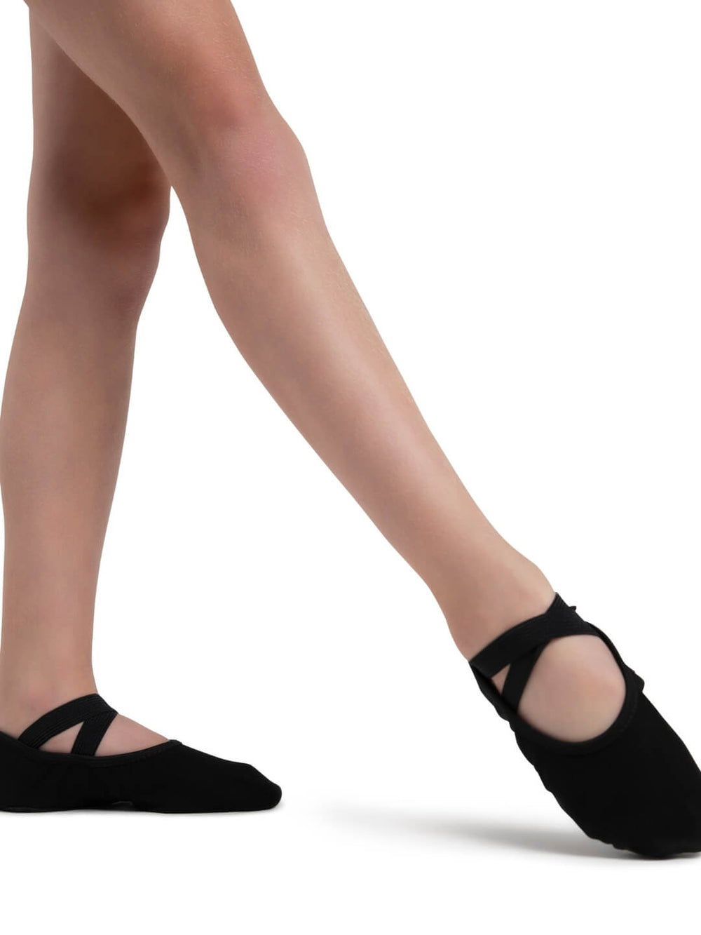 Black ballet shoes worn by a dancer on a white background