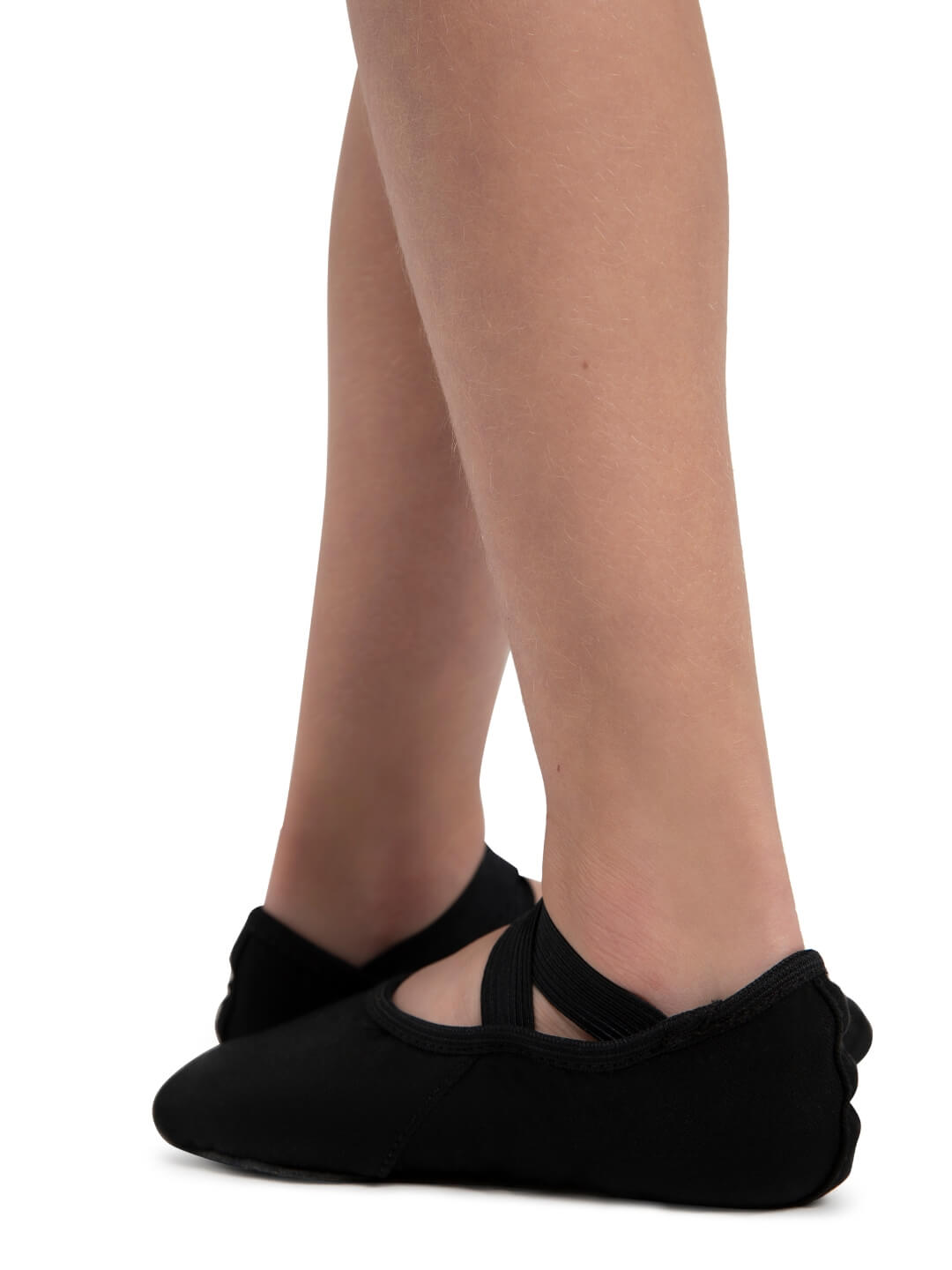 Black ballet shoes worn by a person on a white background