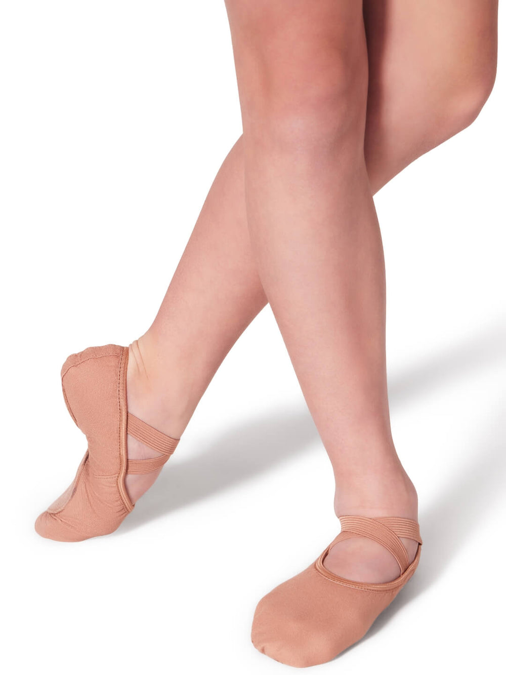 Ballet shoes worn with sheer beige tights on a white background