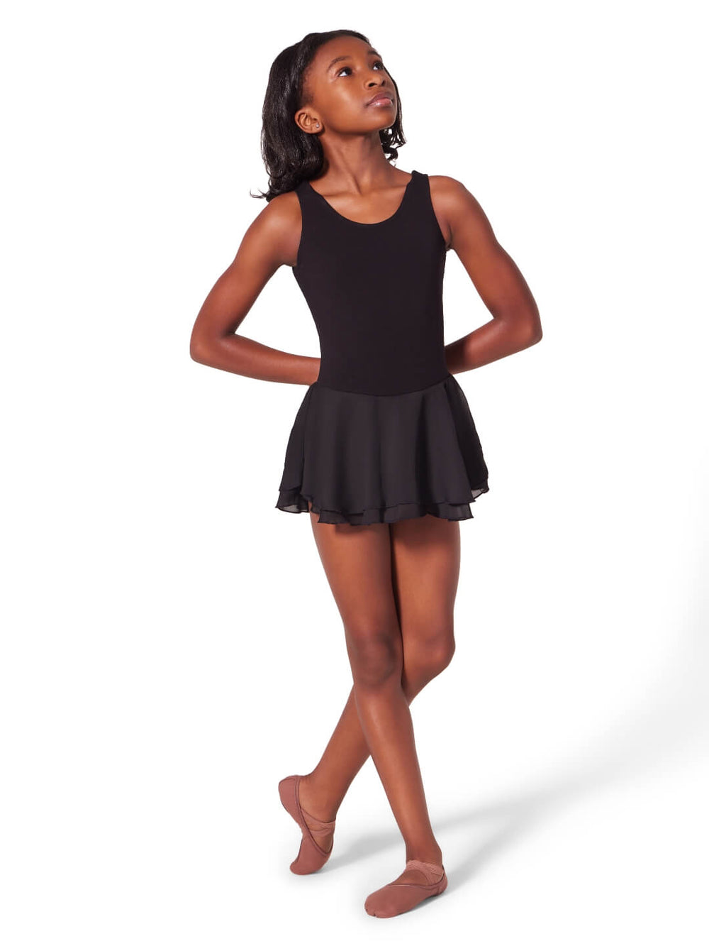 Young girl wearing a black sleeveless dance outfit on a white background