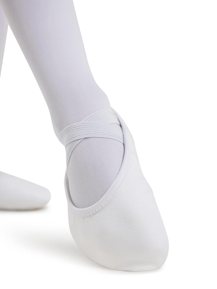 White ballet shoes worn with white tights on a white background