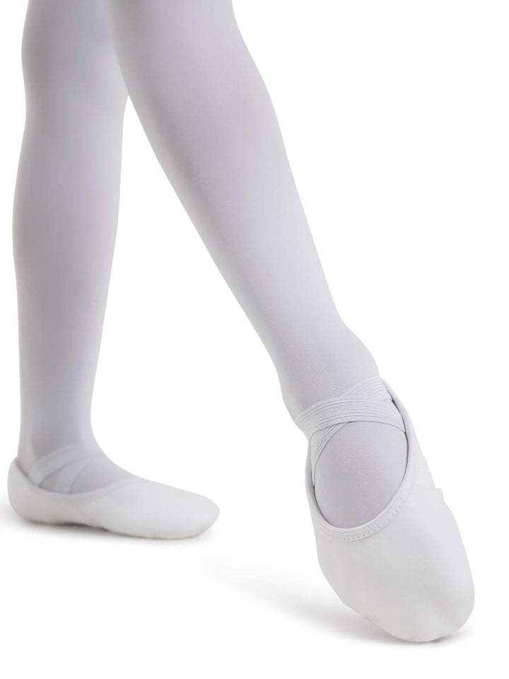 White ballet shoes worn with white tights on a white background