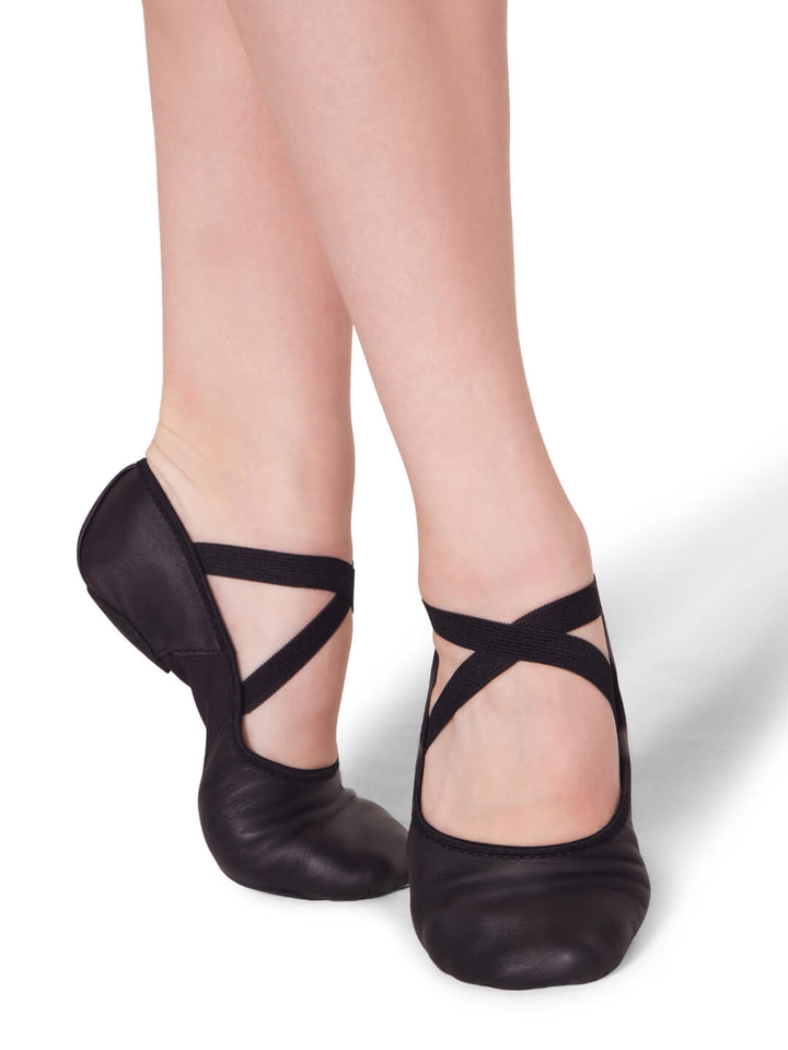 Black dance shoes worn by a person on a white background