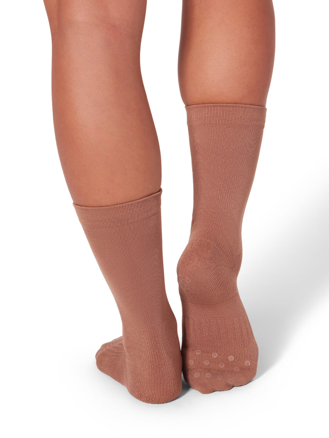 Brown knee-high socks worn by a person on a white background