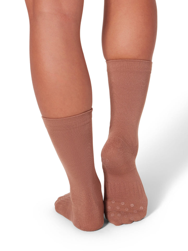 Brown knee-high socks worn by a person on a white background