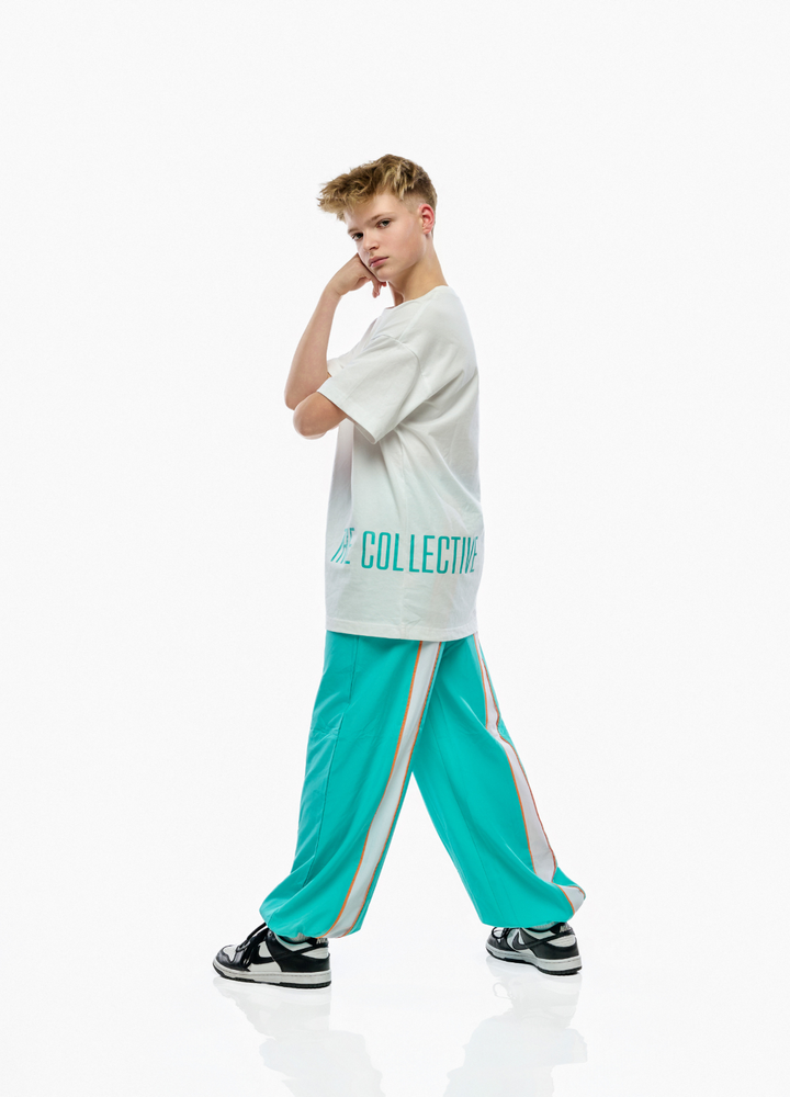 Person wearing a white t-shirt and teal pants with a brand logo on a white background