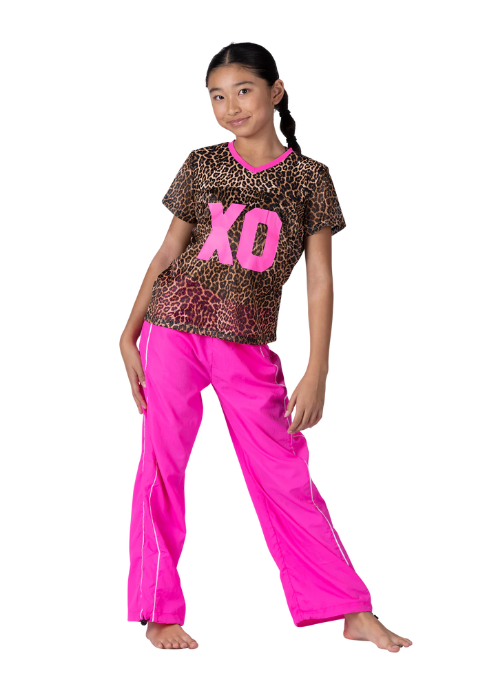 Child wearing a leopard print top with pink 'XO' and pink pants on a white background