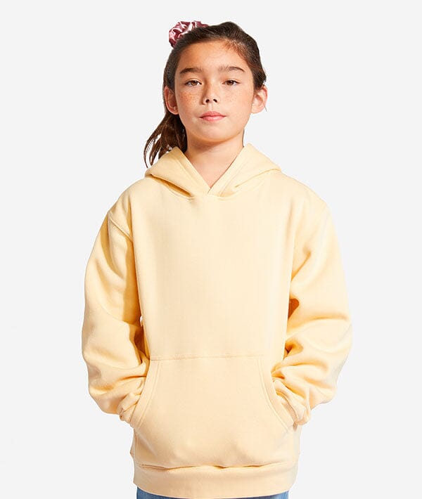Person wearing a light yellow dance hoodie on a white background
