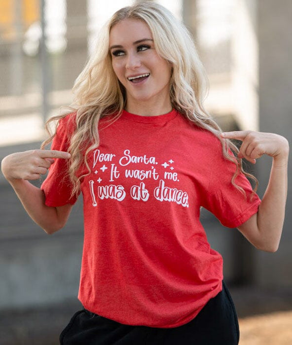 Woman wearing a red t-shirt with a humorous message, standing outdoors.