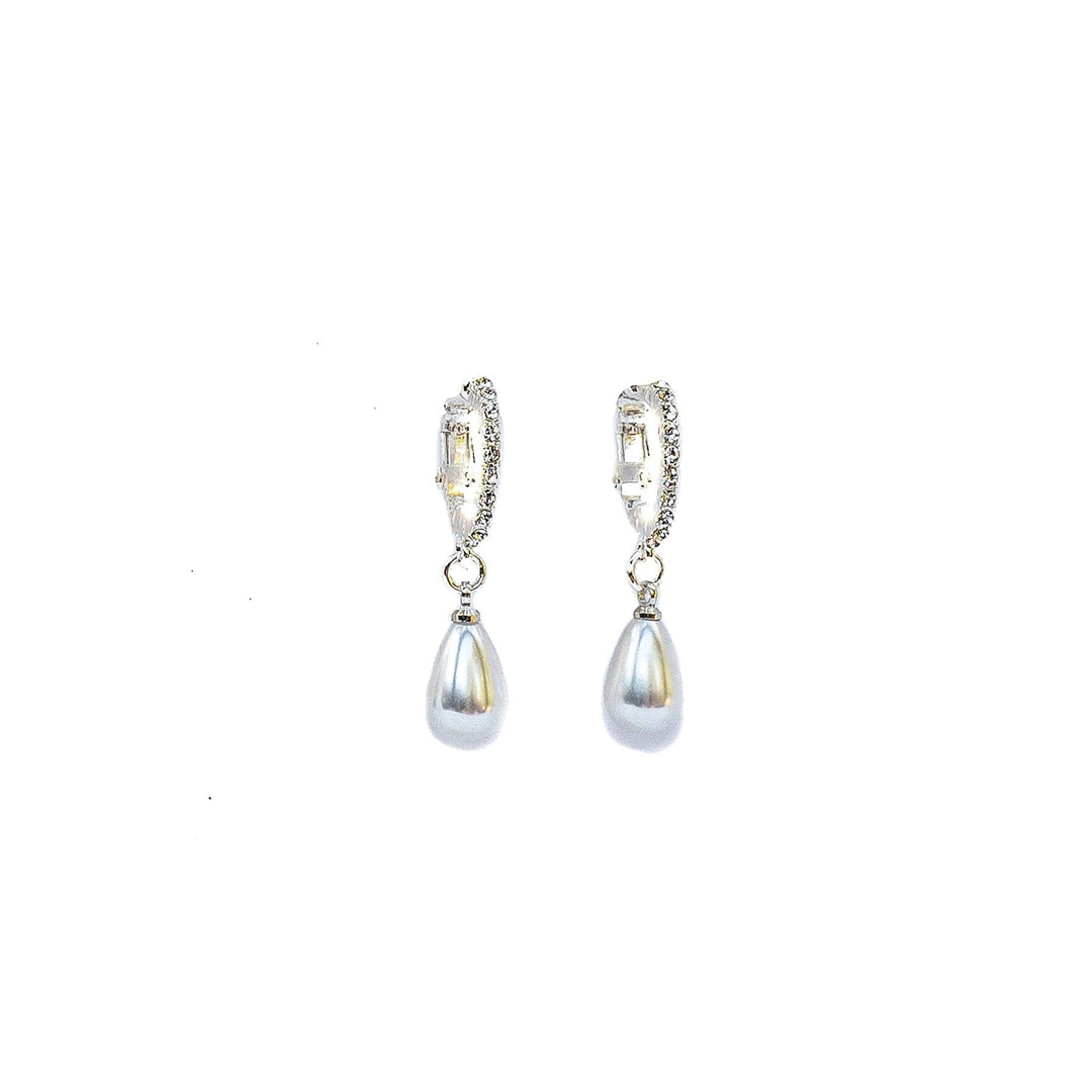 Pair of silver earrings with teardrop-shaped pearls on a white background