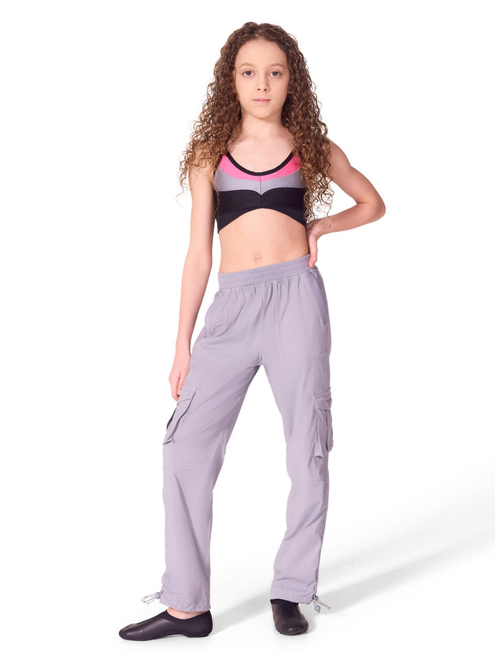 Woman wearing a sports bra and cargo pants on a white background