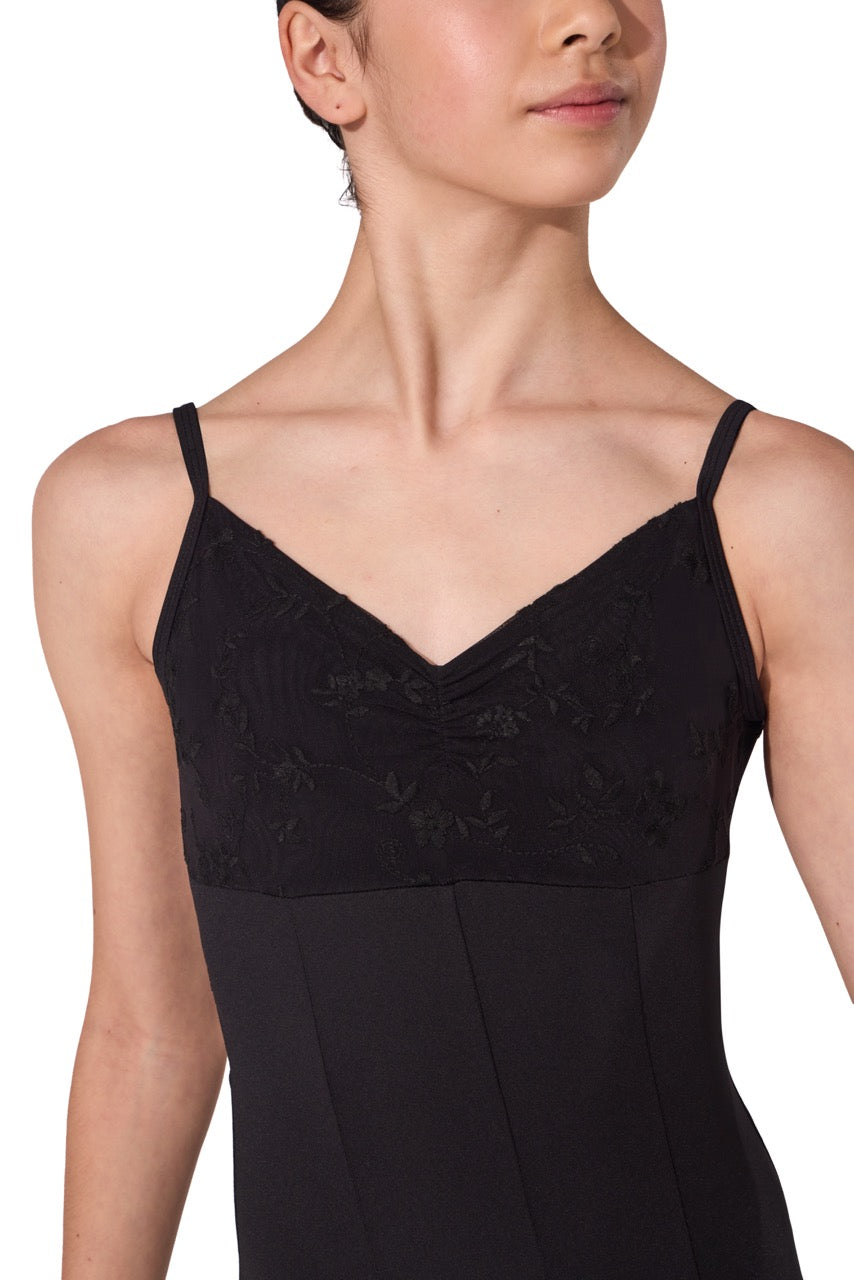 A close-up of a model wearing a black spaghetti-strap camisole top with a lace embroidered bodice and a solid skirt, shown against a plain white background.