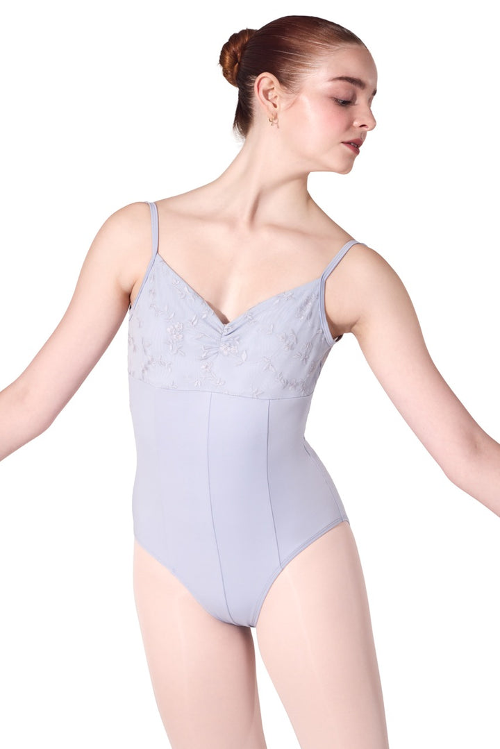 A woman modeling a light lavender-gray ballet leotard with lace detailing on the bust, shown against a plain white background.