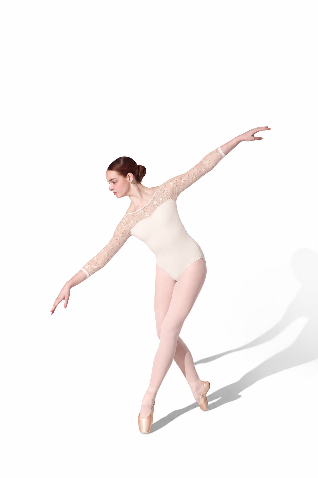 A female ballet dancer in a cream-colored lace and satin leotard, pink tights, and pointe shoes, captured mid-movement on a plain white background with a soft shadow.