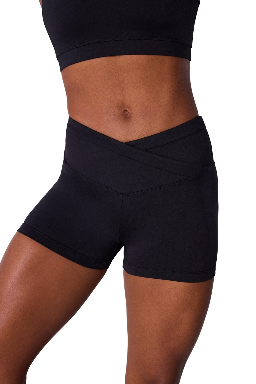 Black high-waisted athletic shorts with a crossover waistband, shown on a model against a white background.