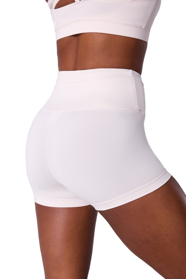 White high-waisted athletic shorts shown on a model from the back, paired with a matching white sports bra against a plain white background.