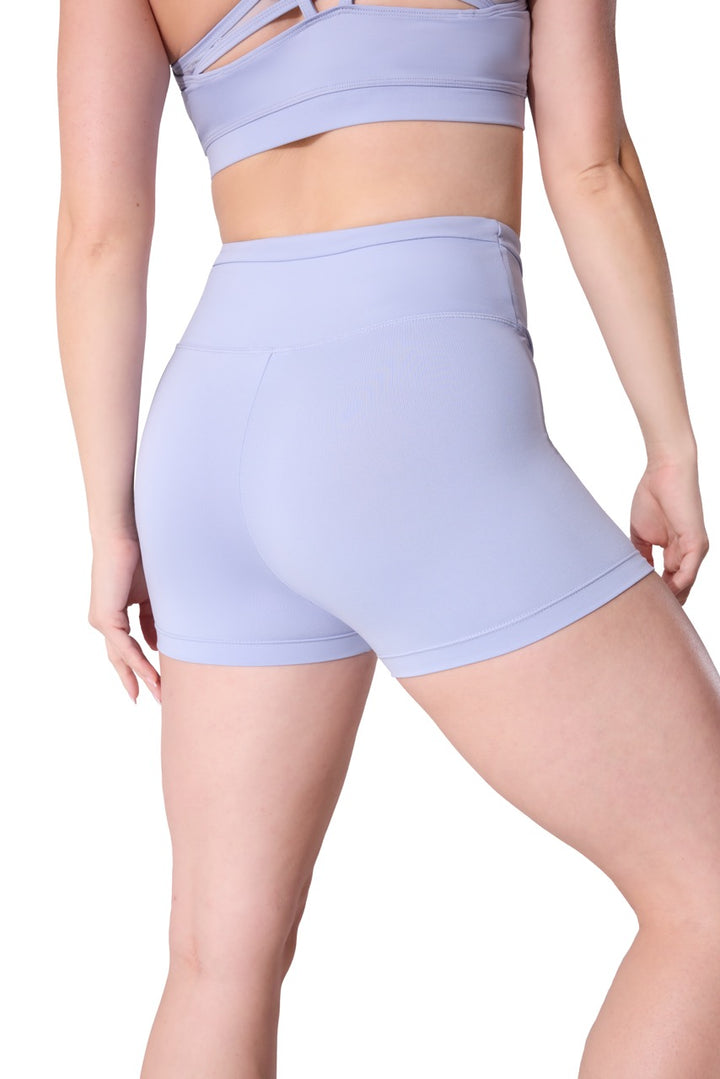 A model shown from the back wearing a matching lavender athletic set consisting of high-waisted shorts and a sports bra, against a plain white background.