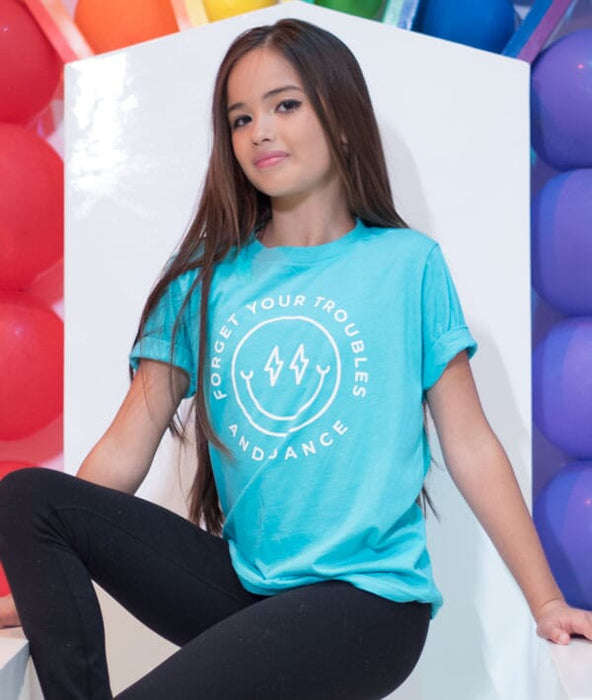 Person wearing a blue t-shirt with text, sitting against a colorful balloon background