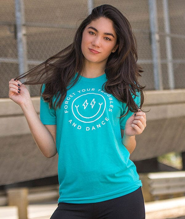 Woman wearing a teal t-shirt with a motivational quote, standing outdoors.