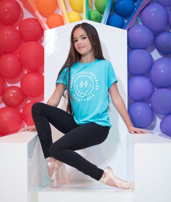 Dancer in a blue t-shirt with colorful balloons in the background
