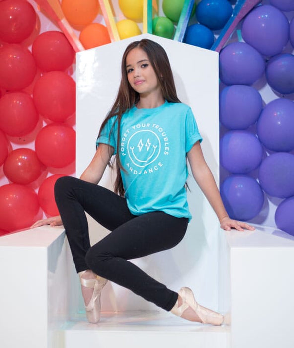 Dancer in a blue t-shirt with colorful balloons in the background