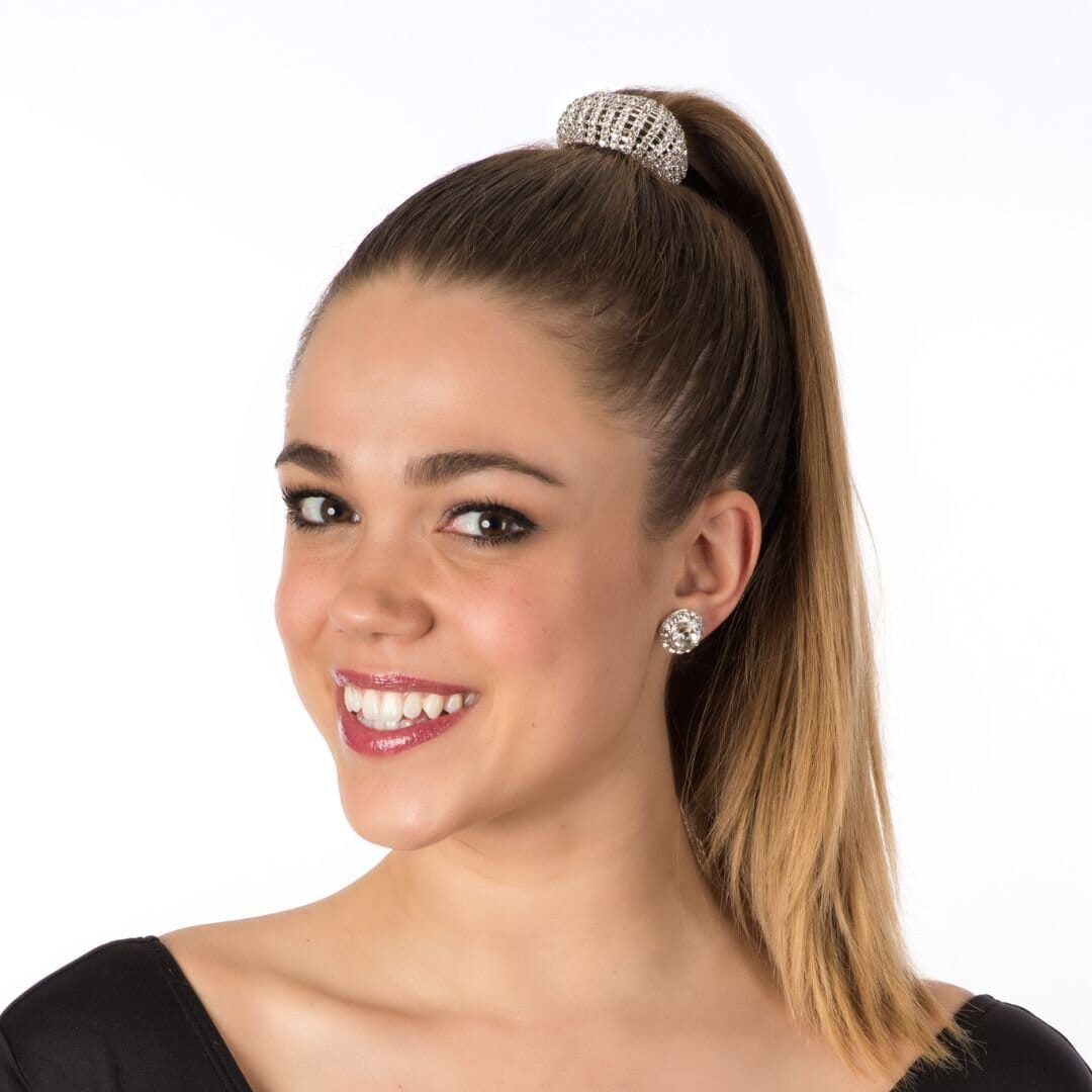 Woman with a high ponytail wearing a hair tie and earrings on a white background