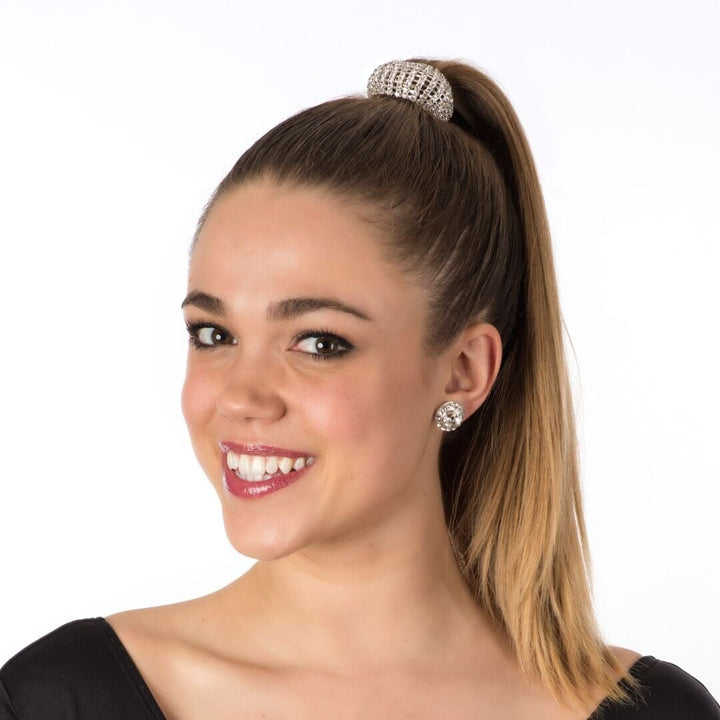Woman with a high ponytail wearing a hair tie and earrings on a white background