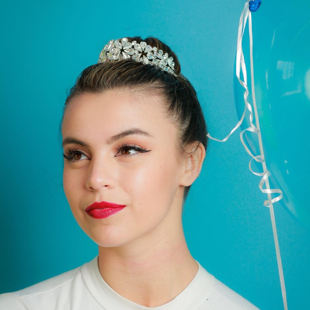 Woman wearing a tiara against a blue background