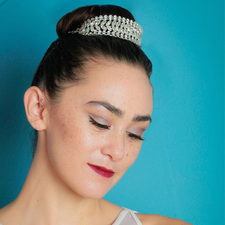 Woman wearing a silver tiara against a blue background