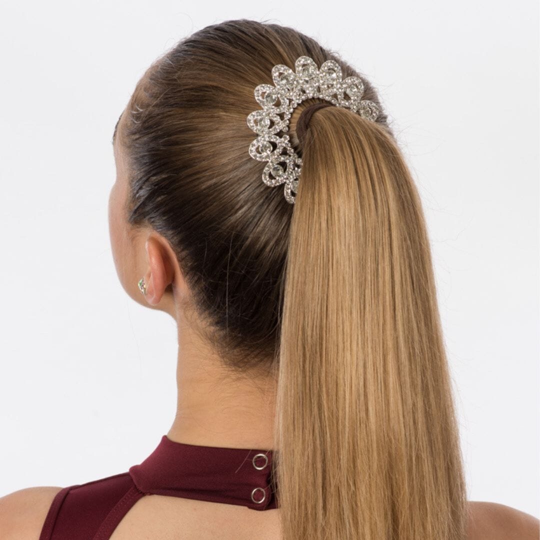 Woman with a high ponytail wearing a decorative hair accessory on a white background