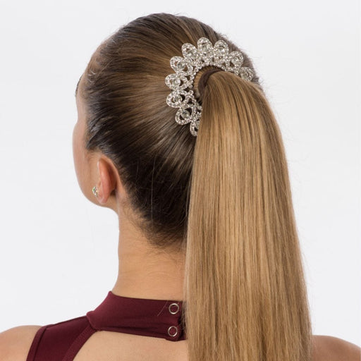 Woman with a high ponytail wearing a decorative hair accessory on a white background