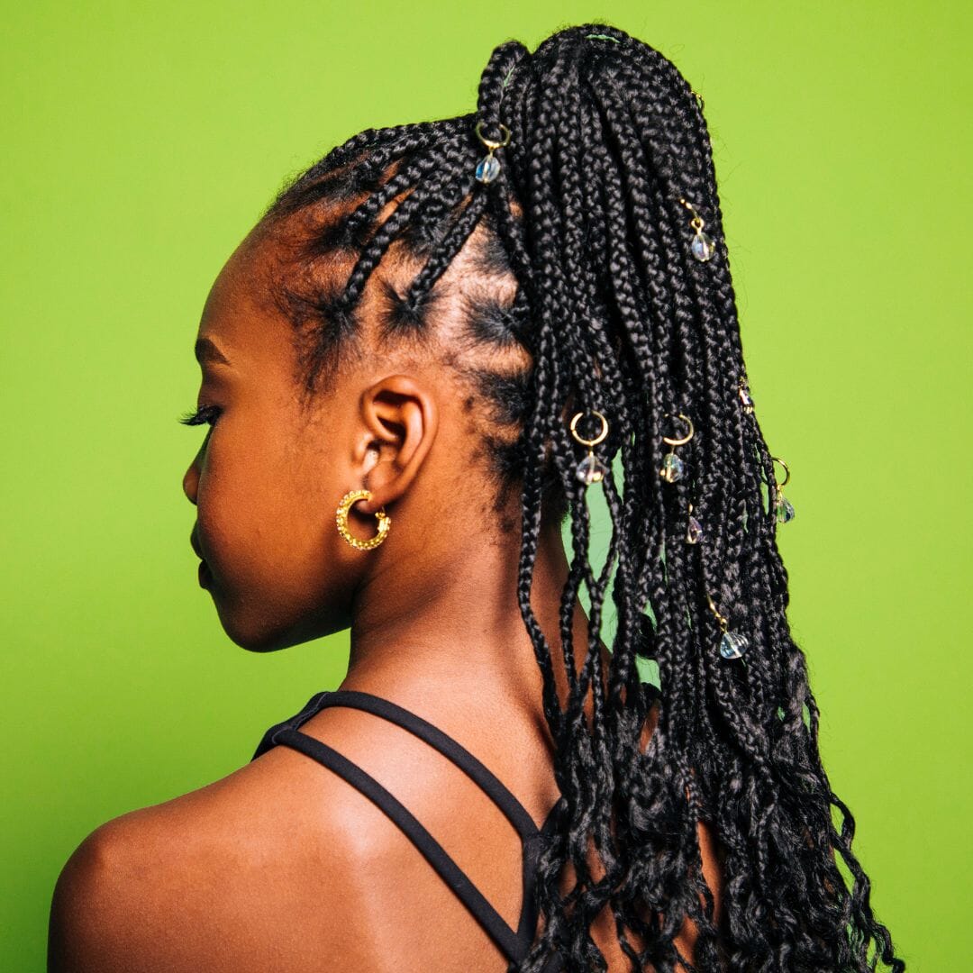 Woman with braided hair against a green background