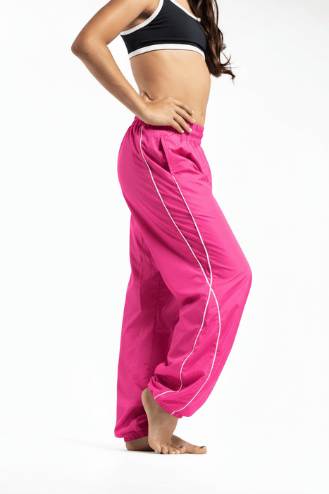 Person wearing bright pink pants with white stripes on a white background