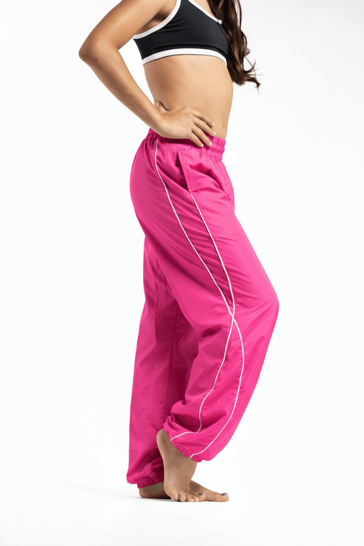 Person wearing bright pink pants with white stripes on a white background