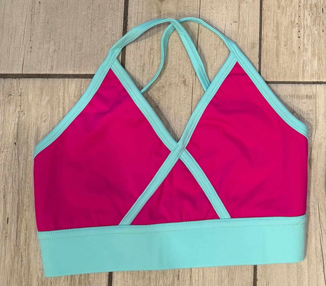 Four colorful bikini tops on a wooden floor