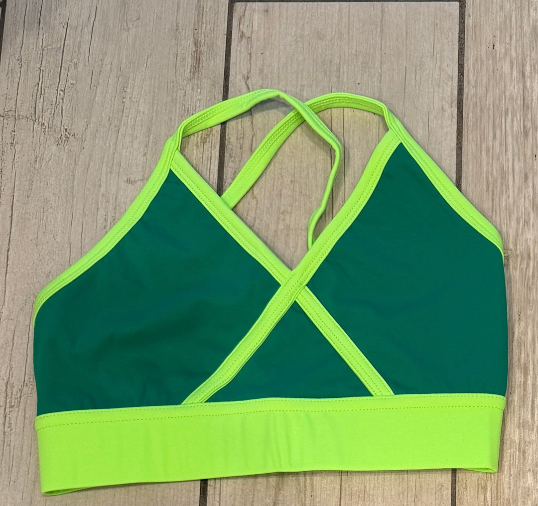 Four colorful bikini tops on a wooden floor