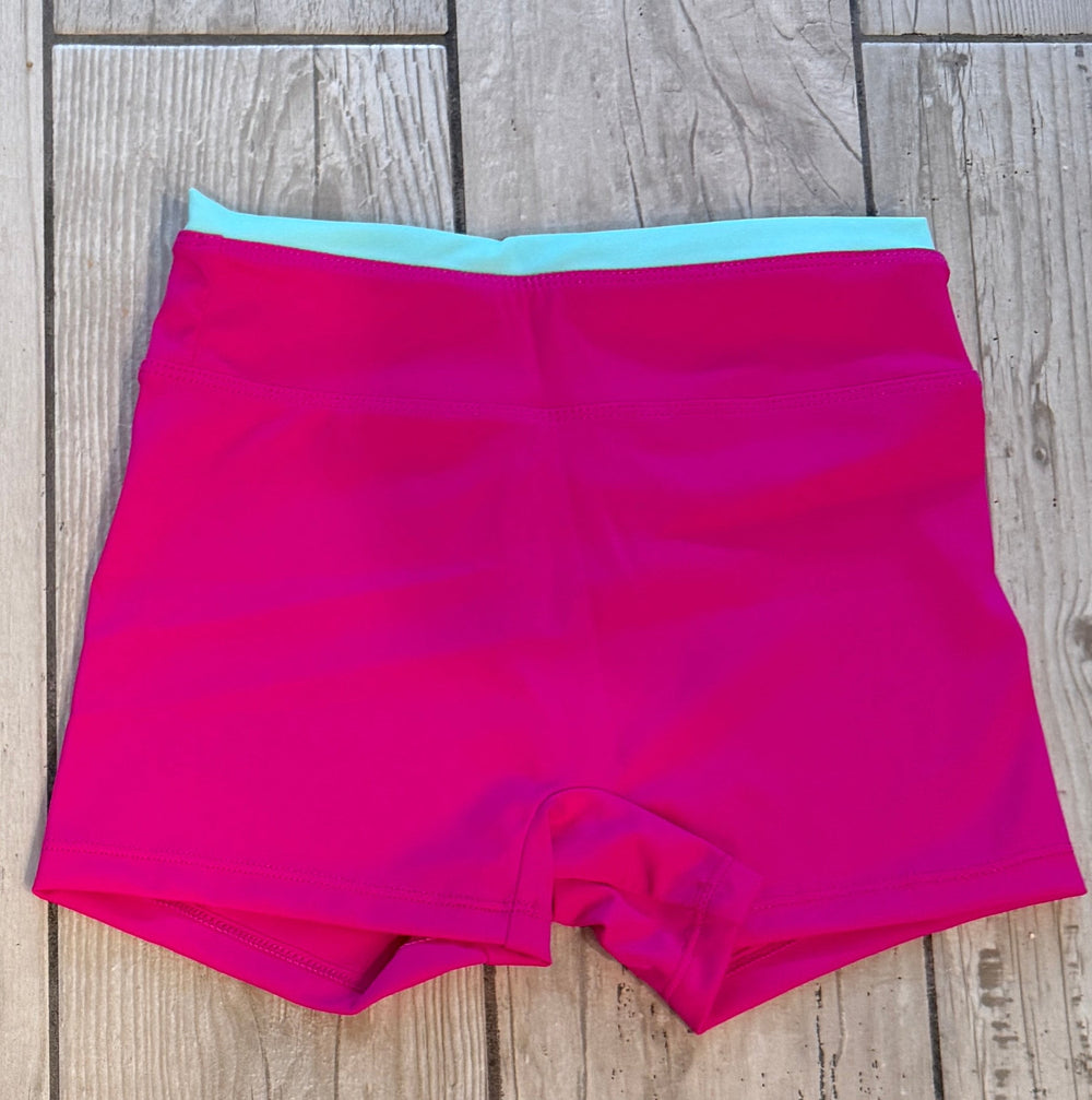 Pink shorts with a blue waistband on a wooden floor