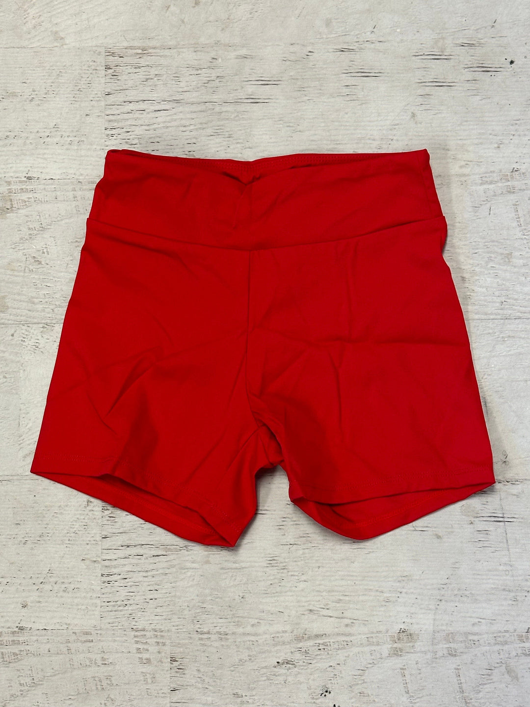 Red shorts on a light wooden surface
