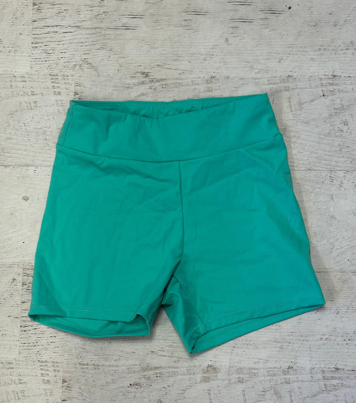 Teal shorts on a textured gray surface