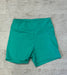 Teal shorts on a textured gray surface
