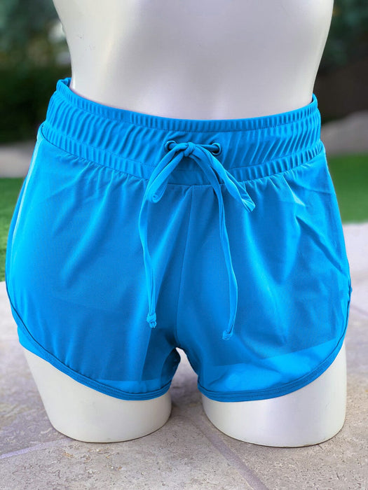 Blue shorts on a mannequin against a blurred outdoor background