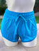 Blue shorts on a mannequin against a blurred outdoor background
