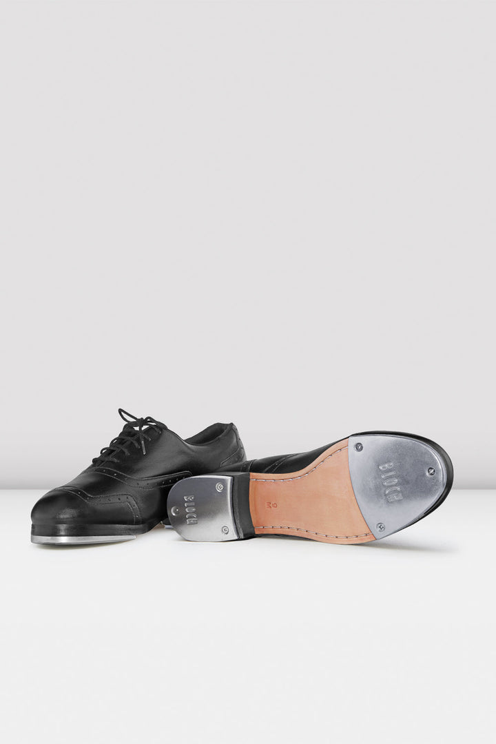 Black tap dance shoes with a white sole on a white background