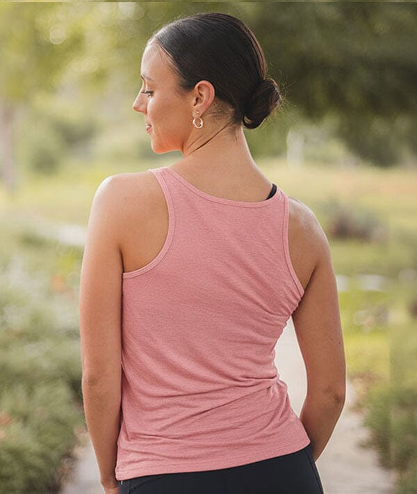 Woman wearing a pink tank top in a natural setting