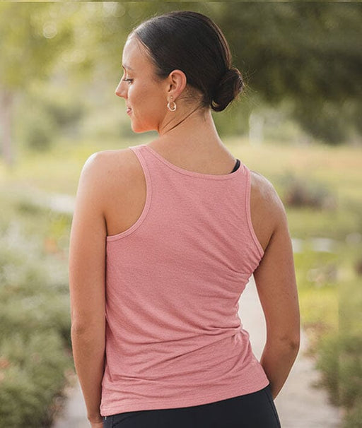Woman wearing a pink tank top in a natural setting