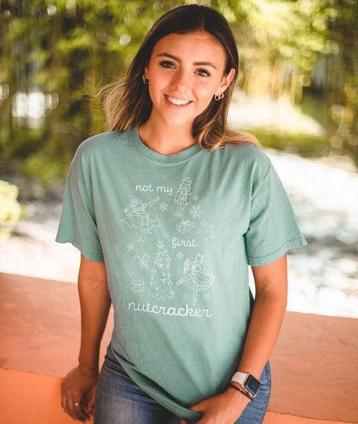 Woman wearing a green t-shirt with a graphic design outdoors